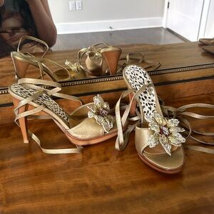 Lace up gold sandals with beaded flower and wood heels.